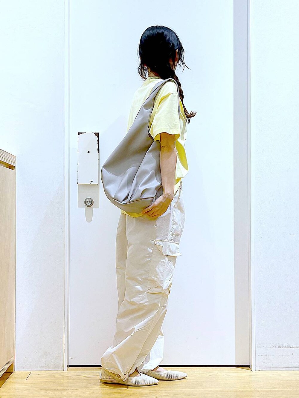 グレー系のトートバッグ、ホワイト系のカーゴパンツ、ホワイト系のパンプスを着用したレディースの春コーディネートの4枚目の写真