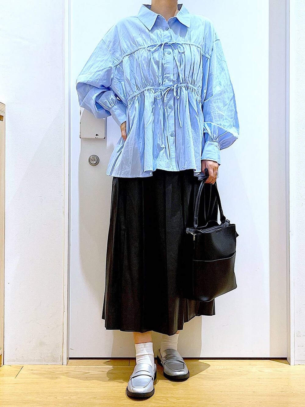 シルバー系のローファー、ブラック系のショルダーバッグ、ブルー系のシャツ/ブラウスを着用したレディースの秋コーディネートの6枚目の写真