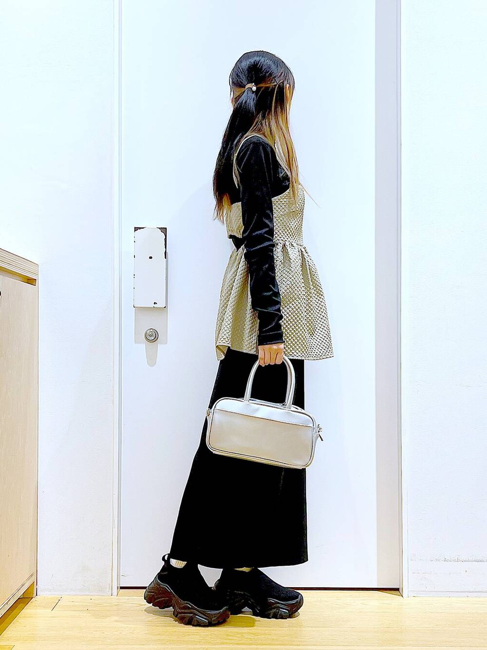 シルバー系のショルダーバッグ、ブラック系のTシャツ/カットソー、ブラック系のスニーカーを着用したレディースの春コーディネートの4枚目の写真