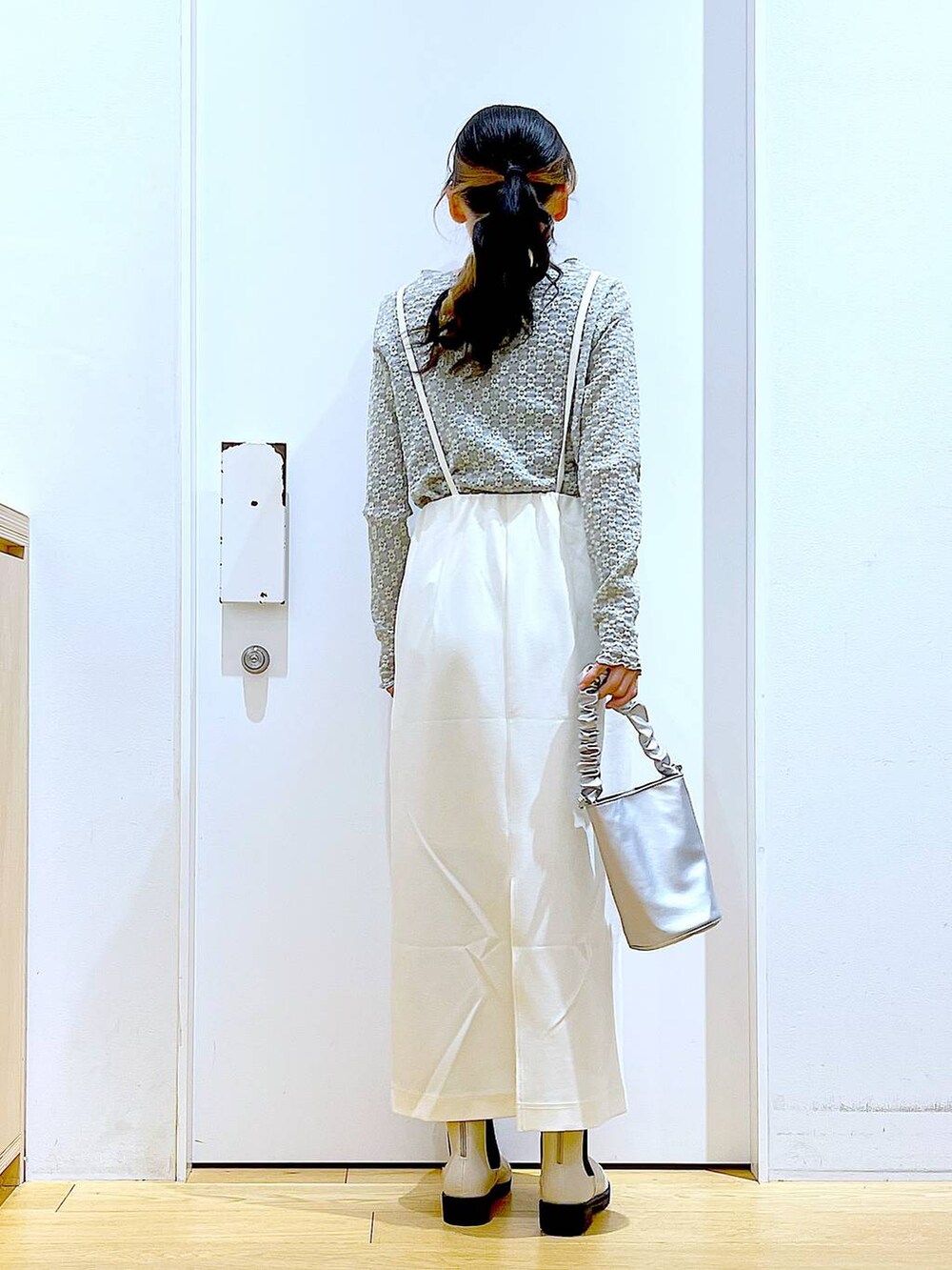 その他のショルダーバッグ、ベージュ系のブーツ、ホワイト系のスカートを着用したレディースの春コーディネートの5枚目の写真