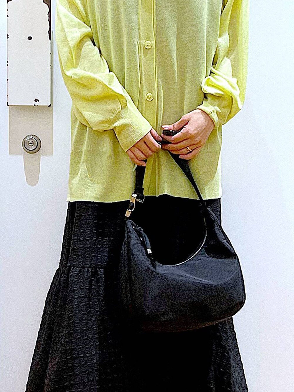 ブラック系のワンピース、グリーン系のカーディガン/ボレロ、ブラック系のショルダーバッグを着用したレディースの春コーディネートの9枚目の写真