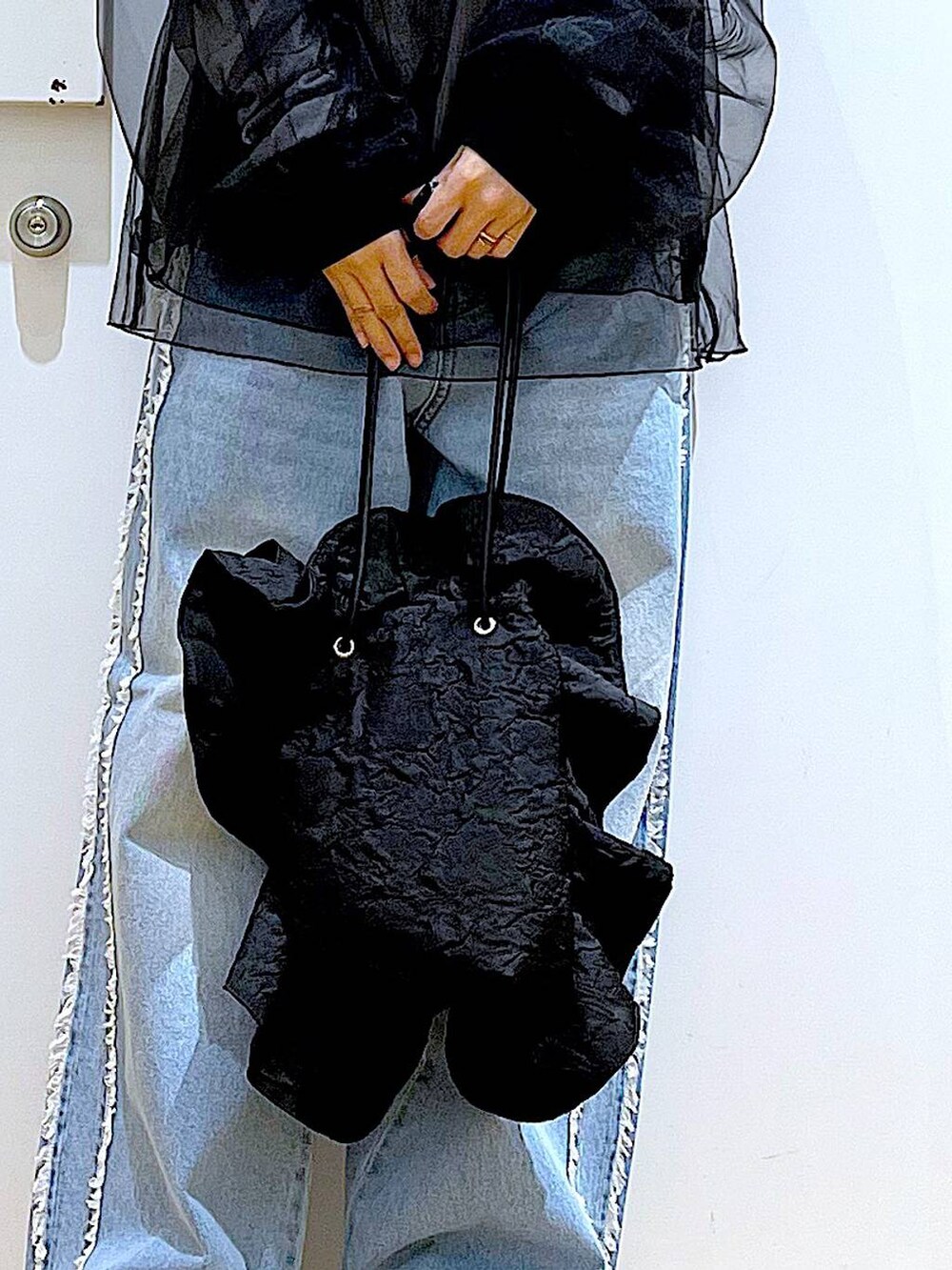 ブラック系のスニーカー、ブラック系のショルダーバッグ、ブルー系のデニムパンツを着用したレディースの春コーディネートの9枚目の写真