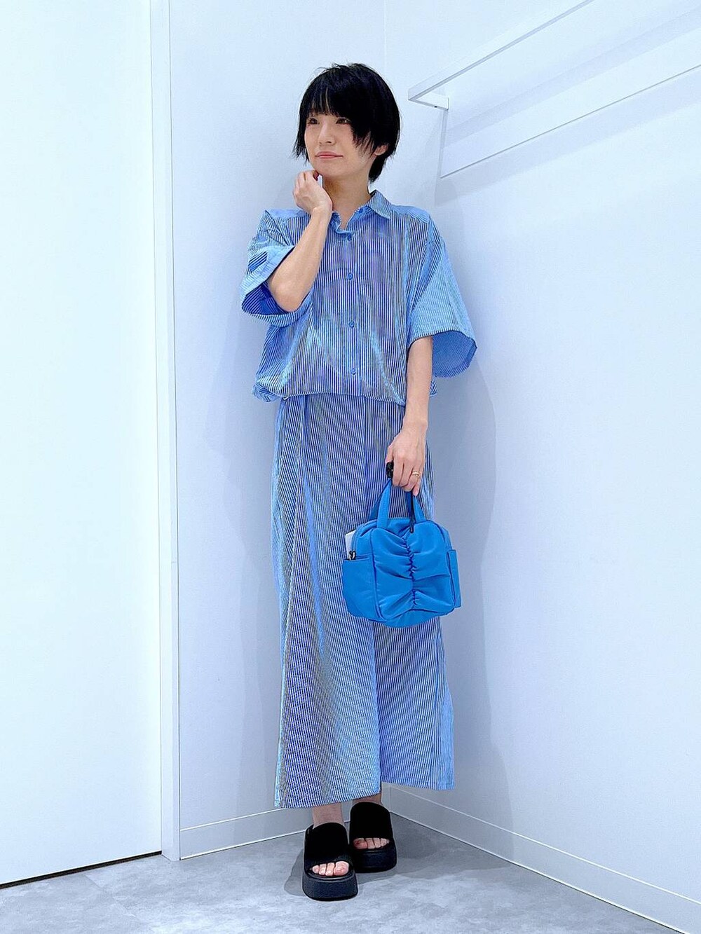 ブラック系のサンダル、ブルー系のワンピースを着用したレディースの夏コーディネートの2枚目の写真