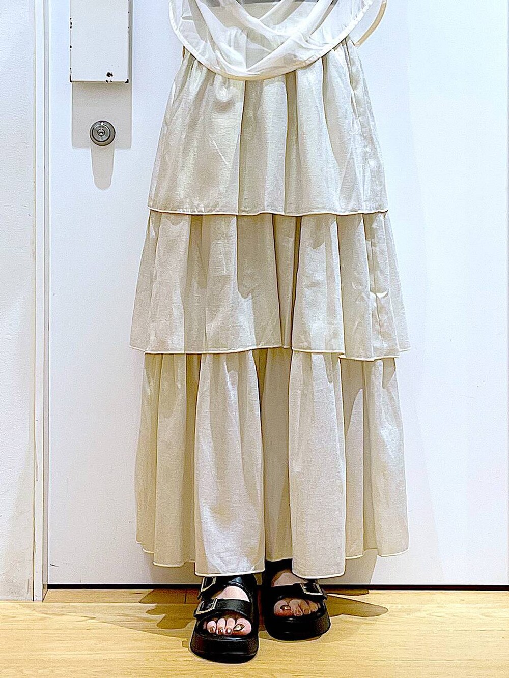 ブラック系のサンダル、ブラック系のショルダーバッグ、ゴールド系のスカートを着用したレディースの夏コーディネートの8枚目の写真