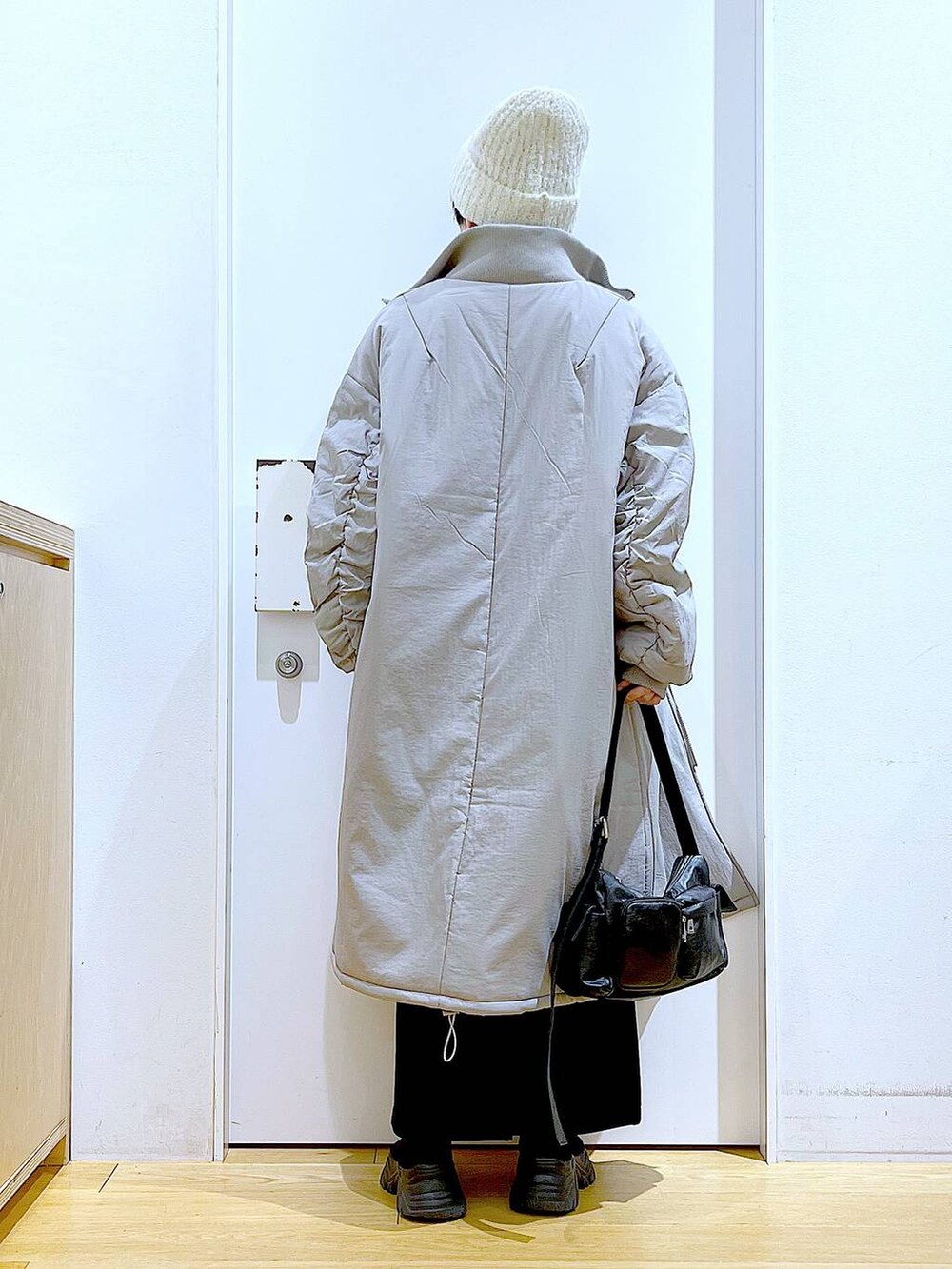 グレー系のミリタリージャケット、ブラック系のブーツ、ブラック系のショルダーバッグを着用したレディースの冬コーディネートの5枚目の写真