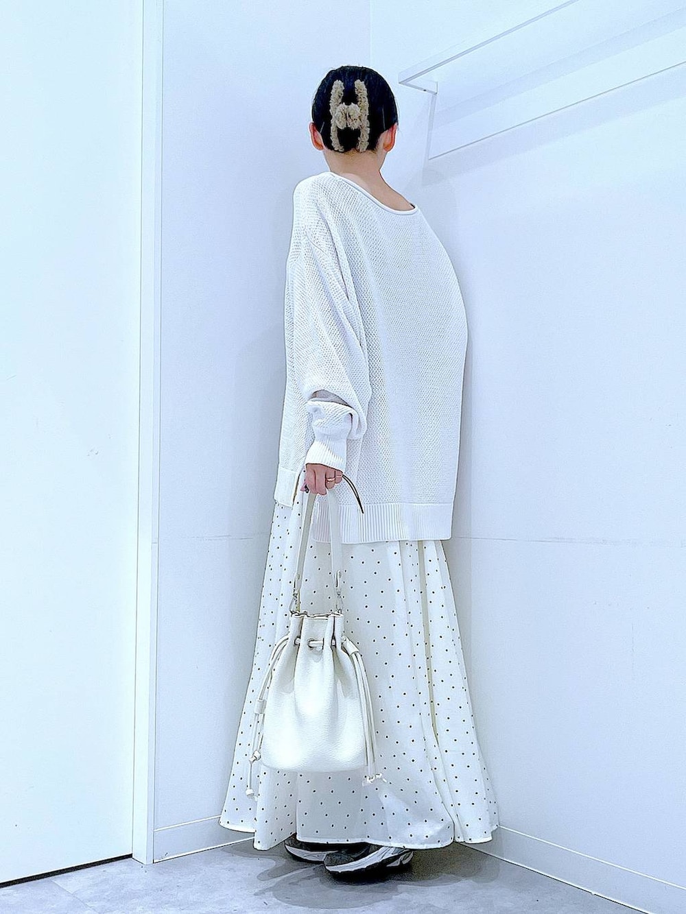 ホワイト系のショルダーバッグ、ホワイト系のスカート、グレー系のバレッタ/ヘアクリップを着用したレディースの春コーディネートの3枚目の写真