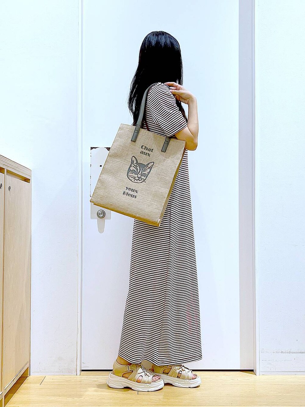 ベージュ系のサンダル、グレー系のトートバッグ、ベージュ系のワンピースを着用したレディースの夏コーディネートの4枚目の写真