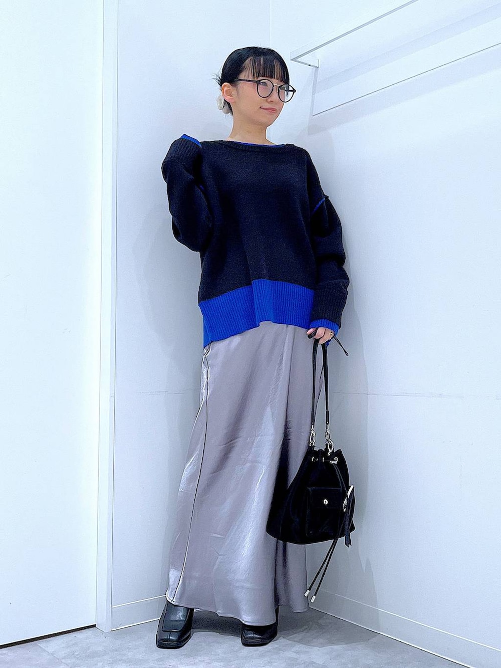 ブラック系のショルダーバッグ、ブラック系のブーツ、ブラック系のニット/セーターを着用したレディースの冬コーディネートの2枚目の写真