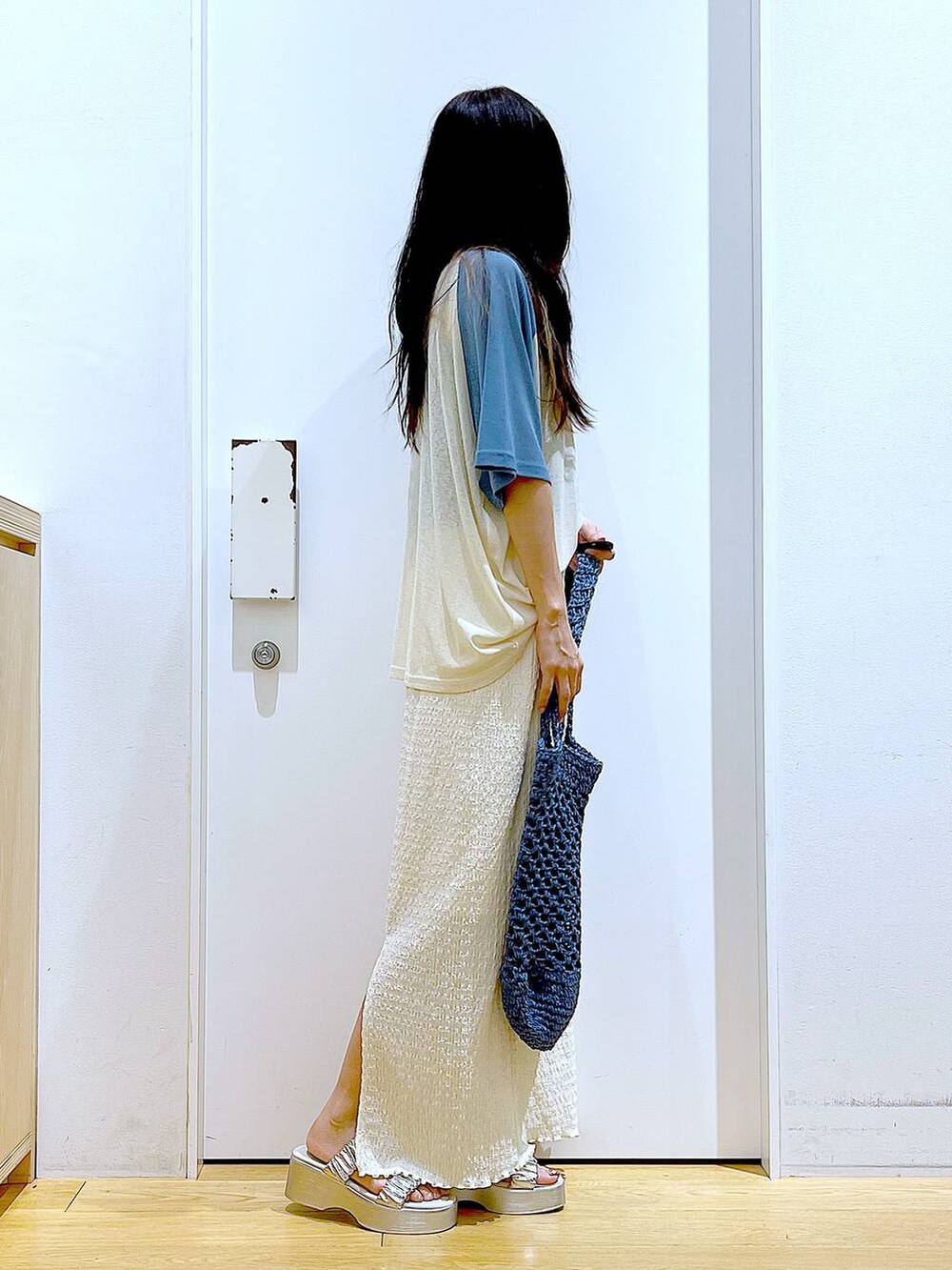 シルバー系のサンダル、ブルー系のトートバッグ、ベージュ系のスカートを着用したレディースの夏コーディネートの4枚目の写真