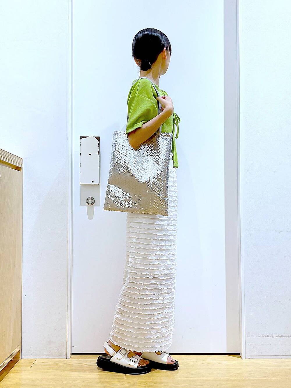 ホワイト系のサンダル、シルバー系のトートバッグ、ホワイト系のスカートを着用したレディースの秋コーディネートの4枚目の写真