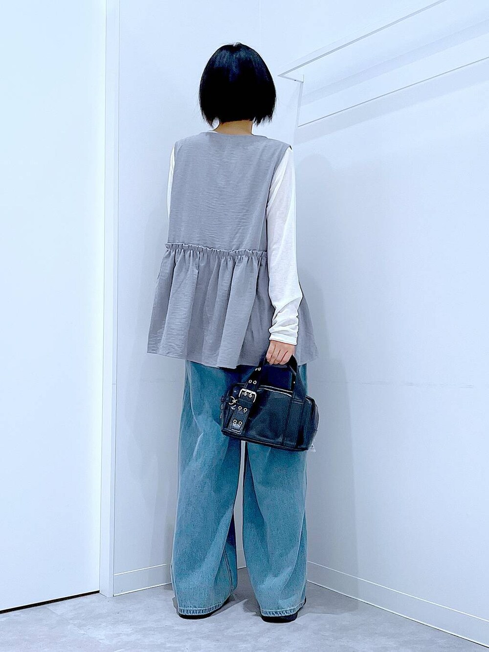 ホワイト系のTシャツ/カットソー、ブラック系のローファー、ブラック系のショルダーバッグを着用したレディースの秋コーディネートの5枚目の写真