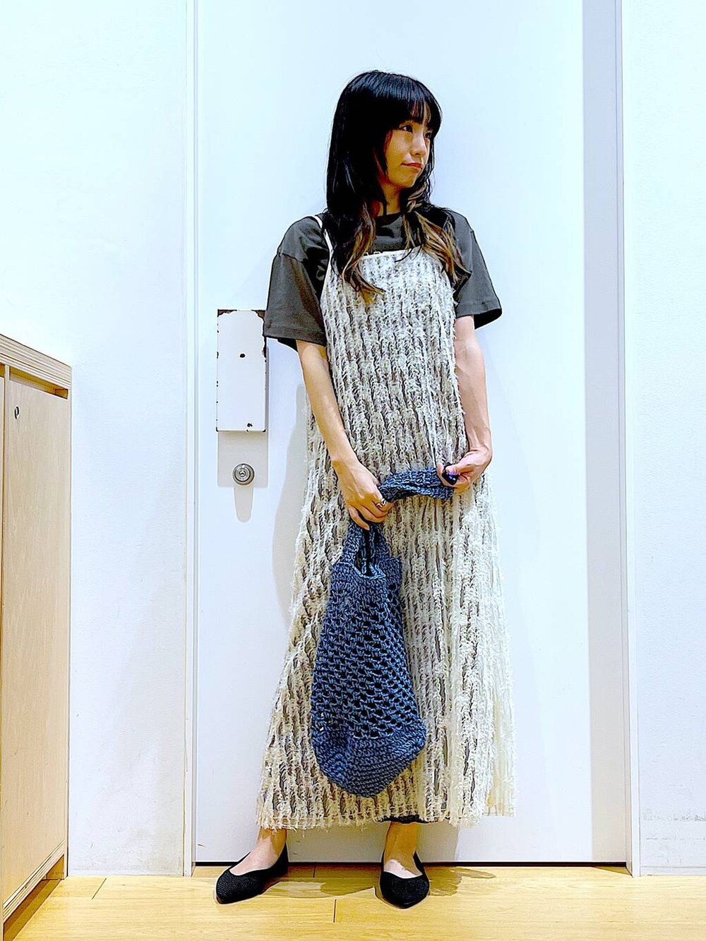 ベージュ系のワンピース、ブラック系のパンプス、ブルー系のトートバッグを着用したレディースの夏コーディネートの2枚目の写真