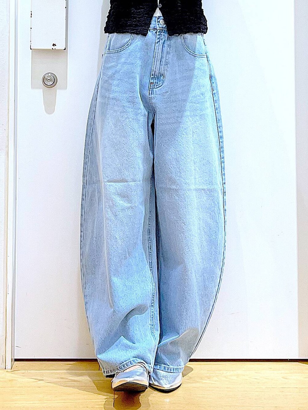 ブラック系のカーディガン/ボレロ、シルバー系のトートバッグ、ブルー系のデニムパンツを着用したレディースの秋コーディネートの8枚目の写真