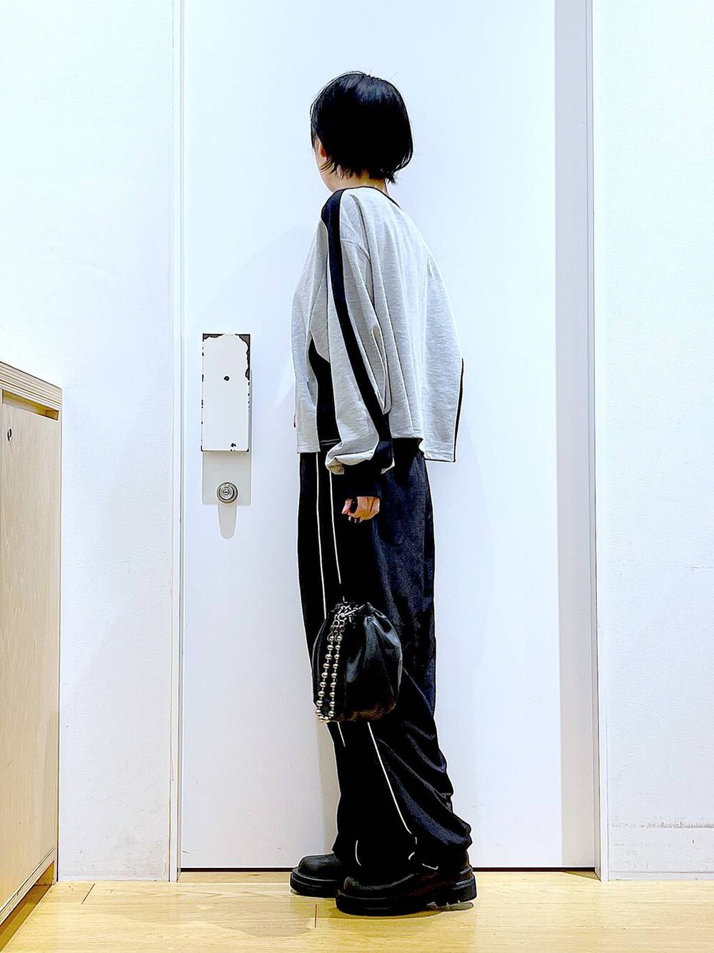 ブラック系のショルダーバッグ、ブラック系のブーツ、グレー系のTシャツ/カットソーを着用したレディースの秋コーディネートの3枚目の写真