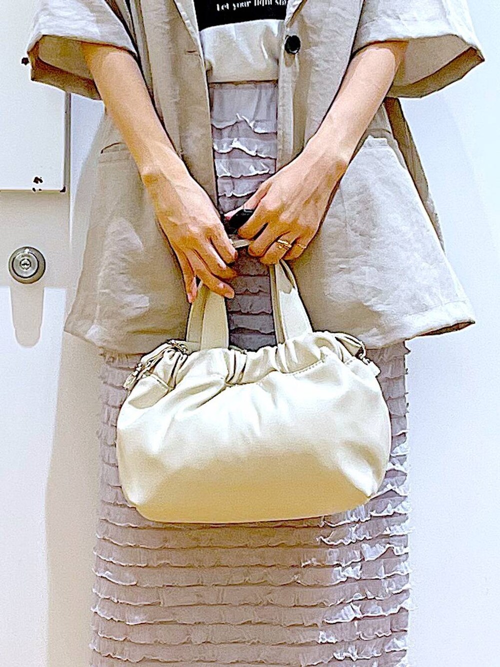 ホワイト系のサンダル、ホワイト系のショルダーバッグ、ホワイト系のTシャツ/カットソーを着用したレディースの夏コーディネートの9枚目の写真