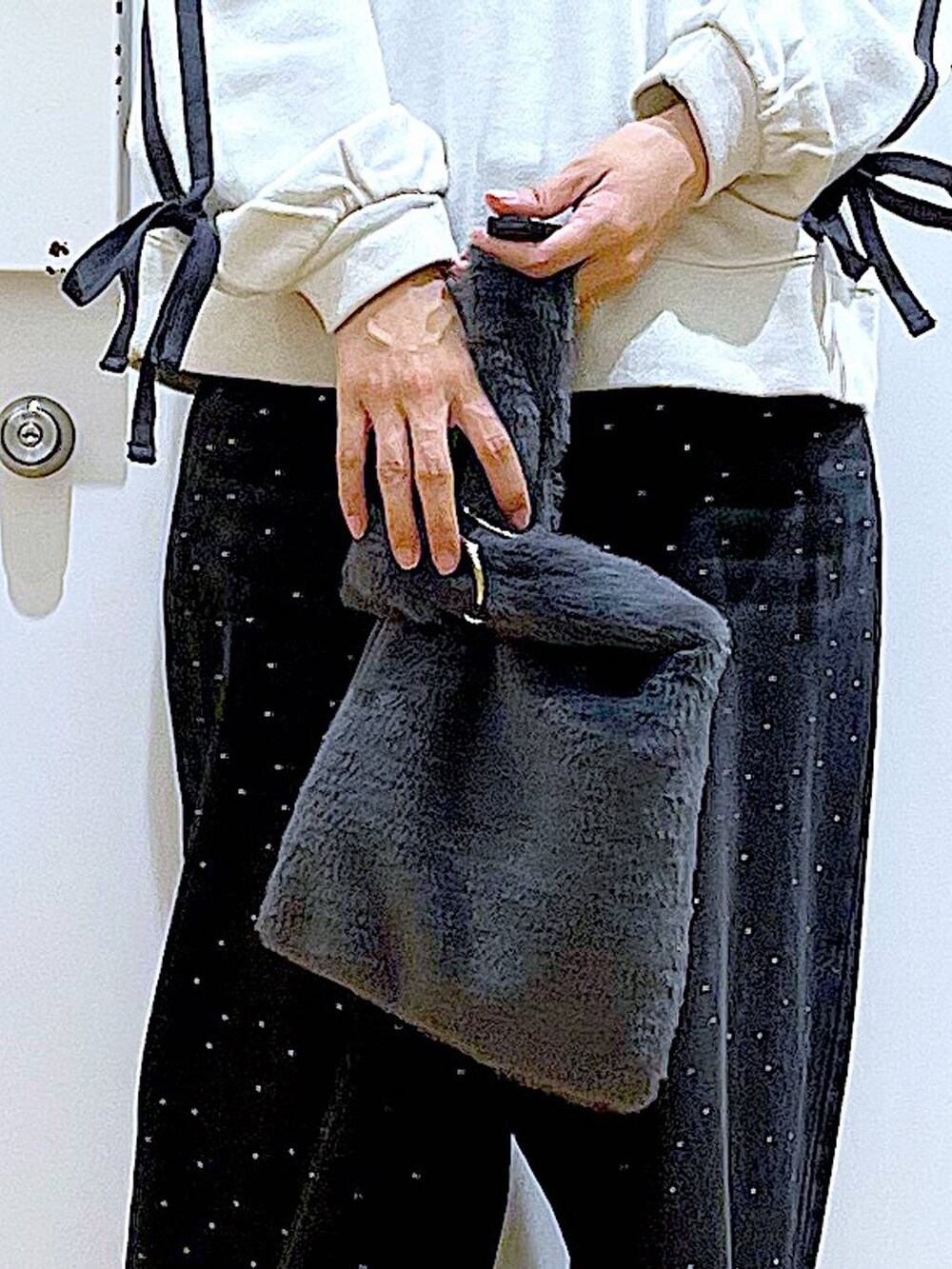 グレー系のショルダーバッグ、ブラック系のブーツ、ベージュ系のスウェットを着用したレディースの秋コーディネートの9枚目の写真