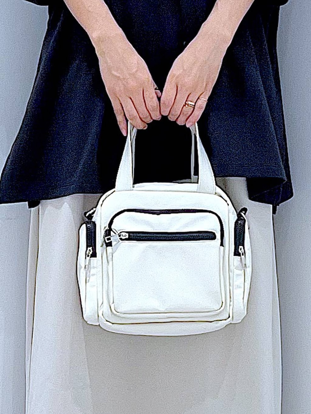 ブラック系のサンダル、ベージュ系のスカート、ホワイト系のショルダーバッグを着用したレディースの夏コーディネートの9枚目の写真