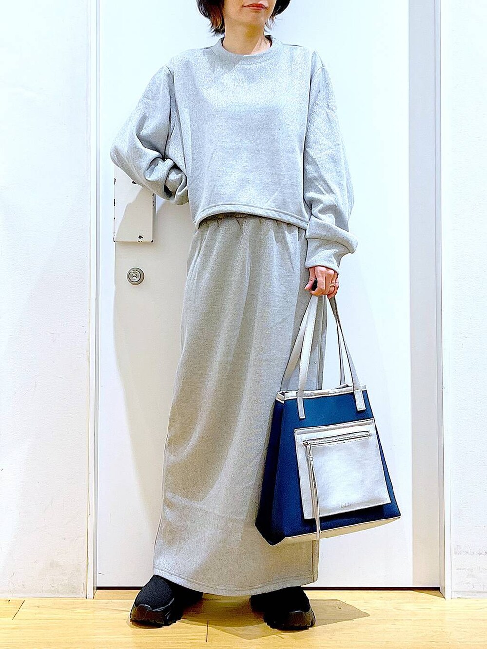 ブラック系のブーツ、ブルー系のトートバッグ、グレー系のスウェットを着用したレディースの冬コーディネートの6枚目の写真