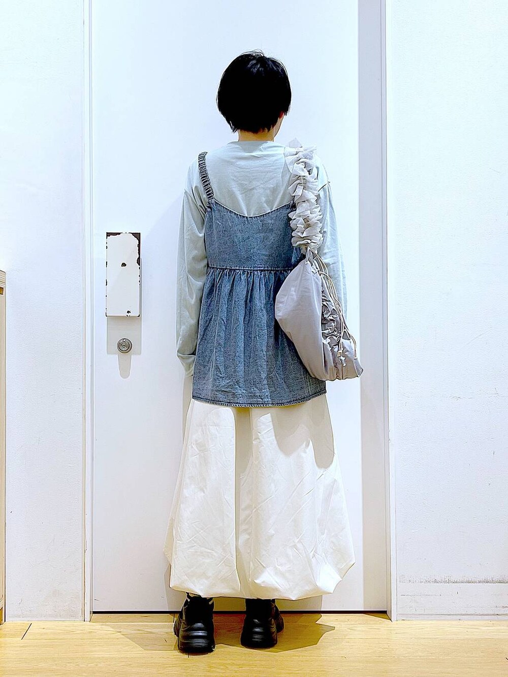 グレー系のショルダーバッグ、ブラック系のスニーカー、ブルー系のその他トップスを着用したレディースの春コーディネートの5枚目の写真