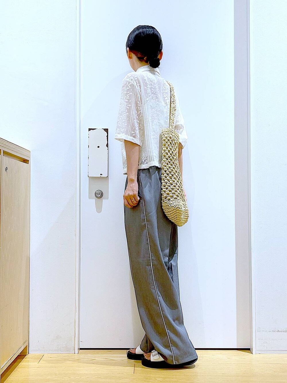 ホワイト系のサンダル、ホワイト系のトートバッグ、ベージュ系のシャツ/ブラウスを着用したレディースの秋コーディネートの3枚目の写真