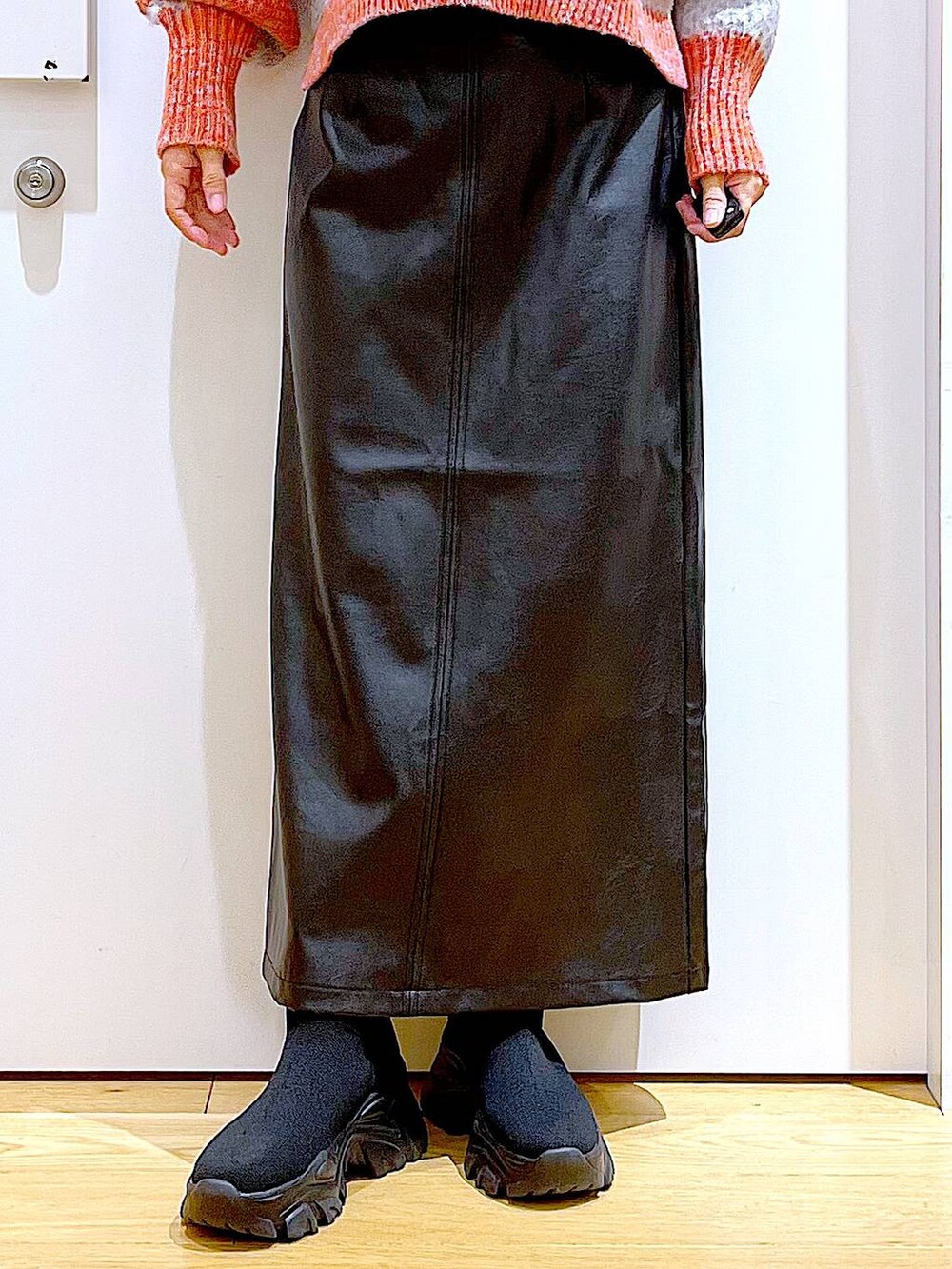 ブラック系のショルダーバッグ、ブラック系のブーツ、ブラック系のスカートを着用したレディースの冬コーディネートの8枚目の写真