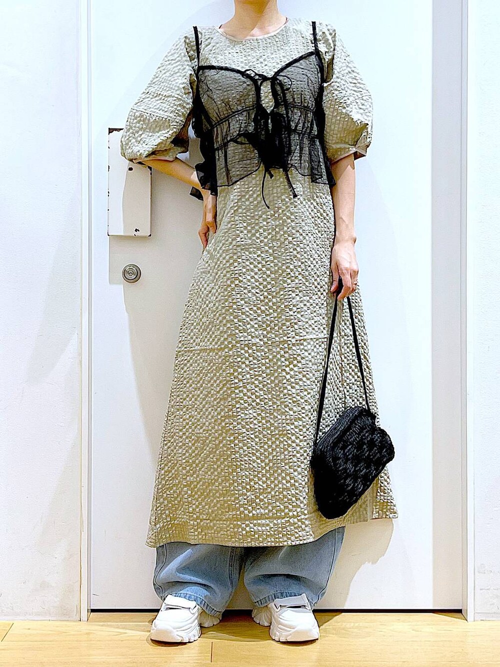 ホワイト系のスニーカー、ブルー系のデニムパンツ、ブラック系のショルダーバッグを着用したレディースの春コーディネートの6枚目の写真