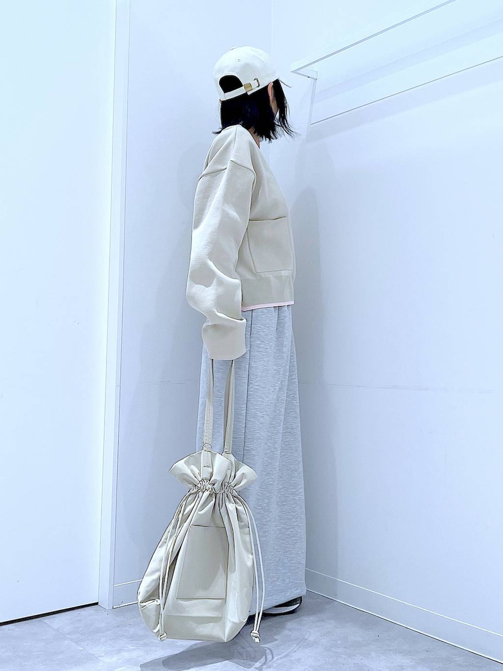 ブラック系のTシャツ/カットソー、ベージュ系のトートバッグ、グレー系のスカートを着用したレディースの冬コーディネートの4枚目の写真