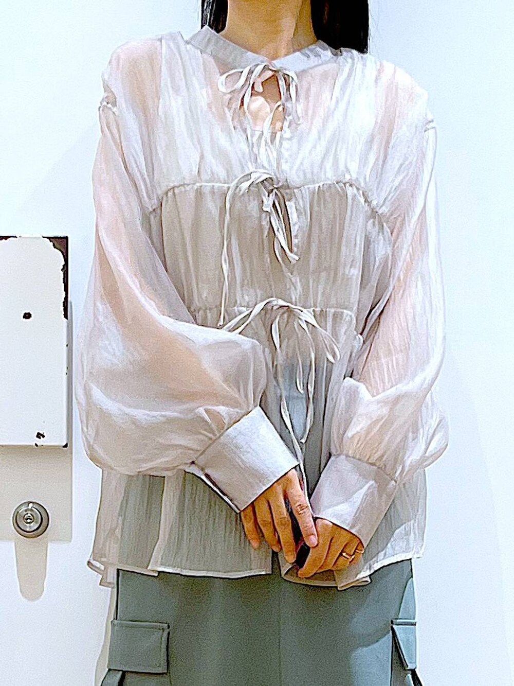 シルバー系のショルダーバッグ、グレー系のシャツ/ブラウス、ホワイト系のパンプスを着用したレディースの春コーディネートの7枚目の写真