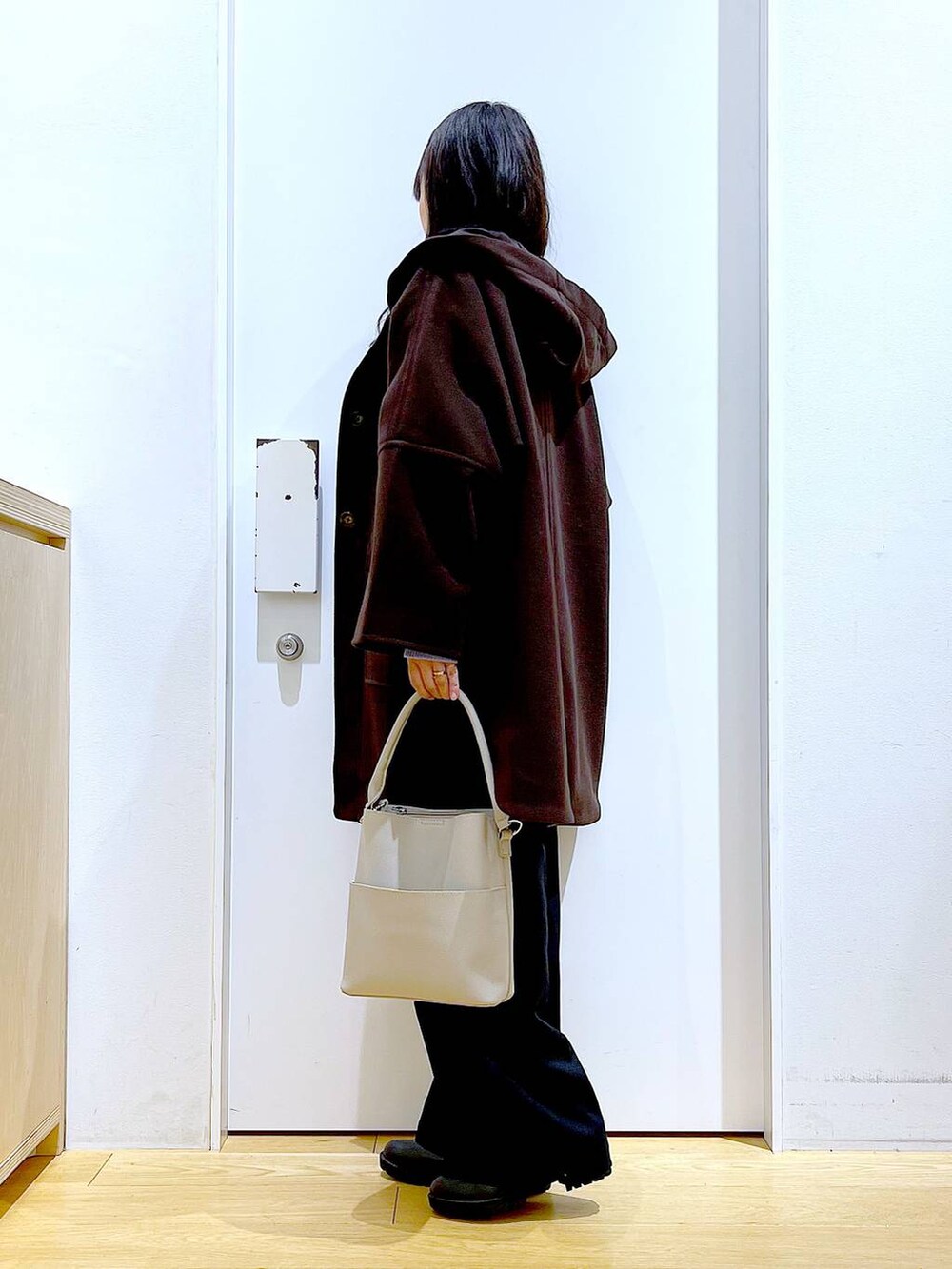 ブラウン系のその他アウター、グレー系のショルダーバッグ、ブラック系のブーツを着用したレディースの冬コーディネートの3枚目の写真