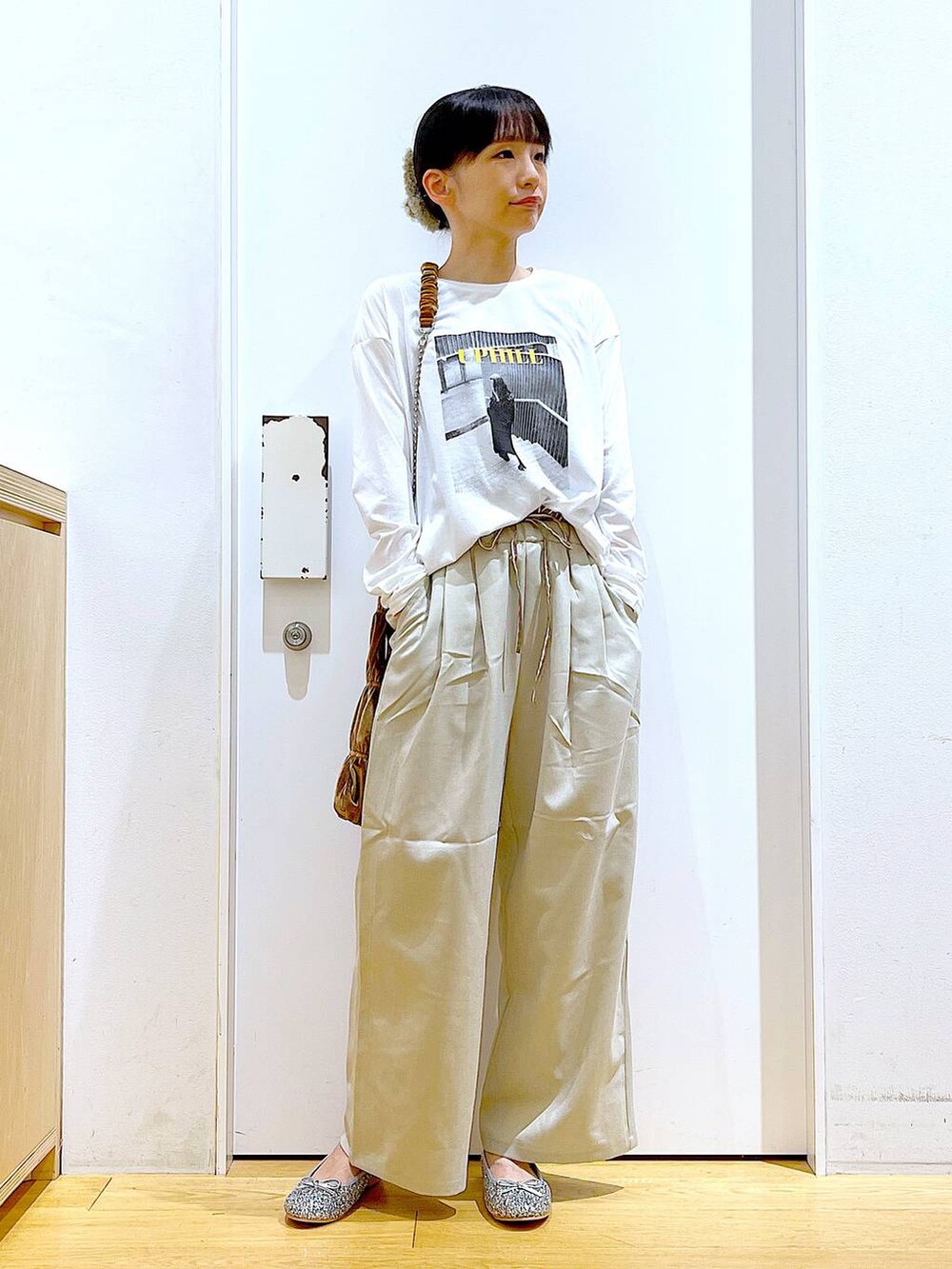 シルバー系のパンプス、イエロー系のショルダーバッグ、ベージュ系のその他パンツを着用したレディースの秋コーディネートの2枚目の写真