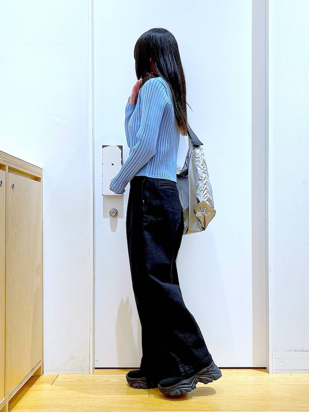 グレー系のデニムパンツ、ブルー系のカーディガン/ボレロ、ブラック系のブーツを着用したレディースの冬コーディネートの3枚目の写真