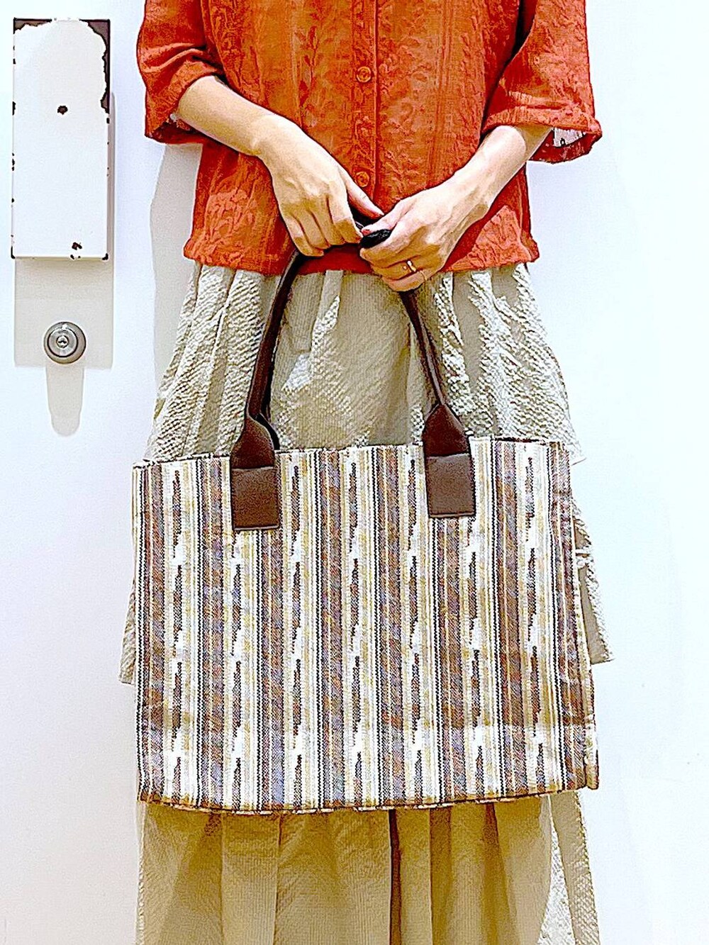 ホワイト系のサンダル、ベージュ系のスカート、レッド系のシャツ/ブラウスを着用したレディースの夏コーディネートの9枚目の写真