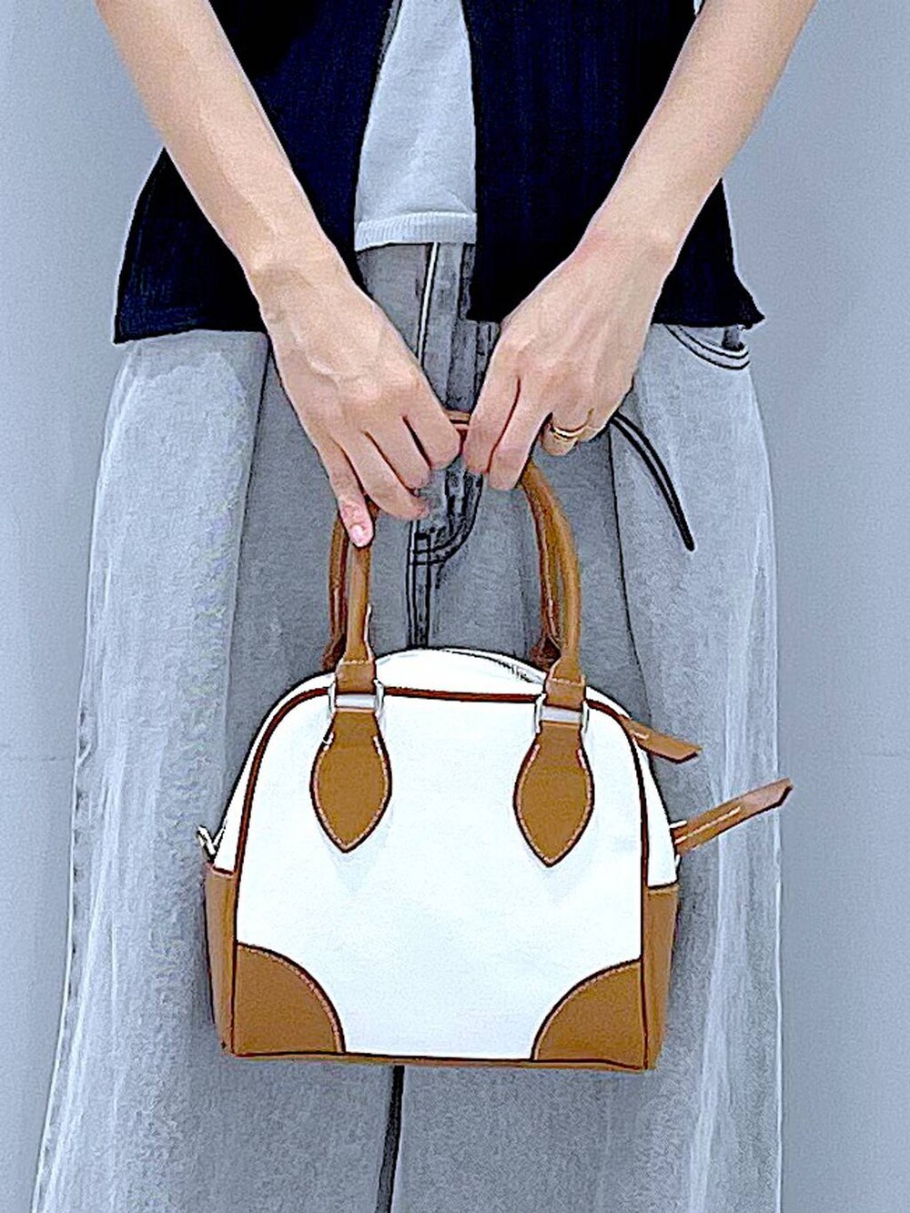 ブラック系のローファー、ホワイト系のハンドバッグ、ブラック系のニット/セーターを着用したレディースの秋コーディネートの9枚目の写真