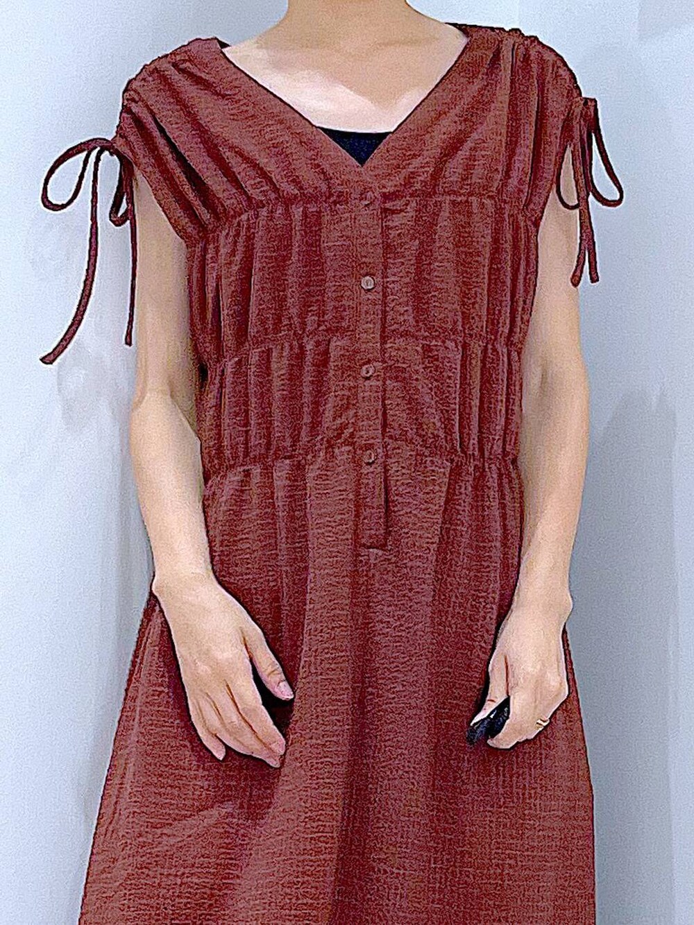 ブラック系のサンダル、ホワイト系のショルダーバッグ、ブラウン系のワンピースを着用したレディースの夏コーディネートの7枚目の写真