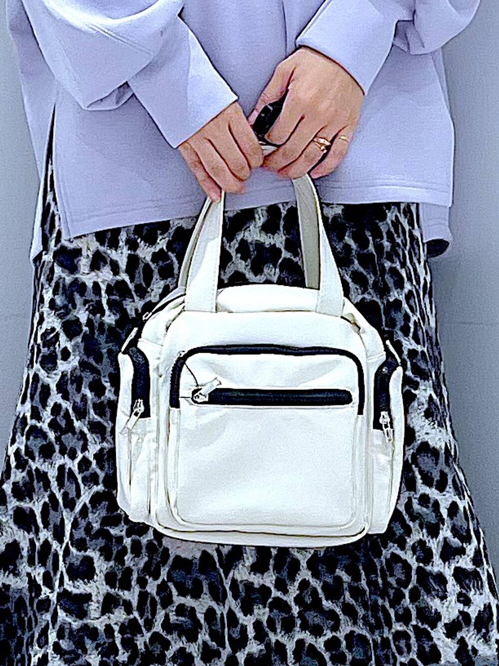 ホワイト系のショルダーバッグ、ブラック系のローファー、グレー系のスカートを着用したレディースの秋コーディネートの9枚目の写真