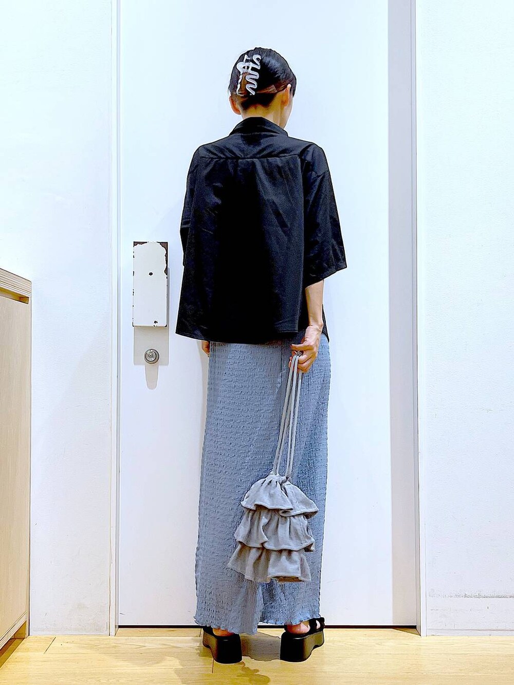 ブラック系のサンダル、ブルー系のスカート、グレー系のショルダーバッグを着用したレディースの秋コーディネートの5枚目の写真