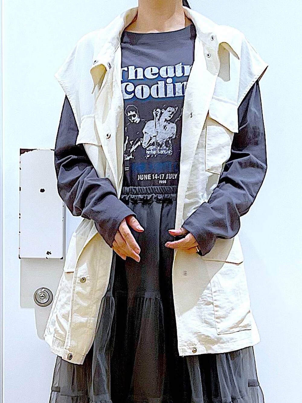 グレー系のスカート、ブラック系のスニーカー、ホワイト系のベストを着用したレディースの春コーディネートの7枚目の写真