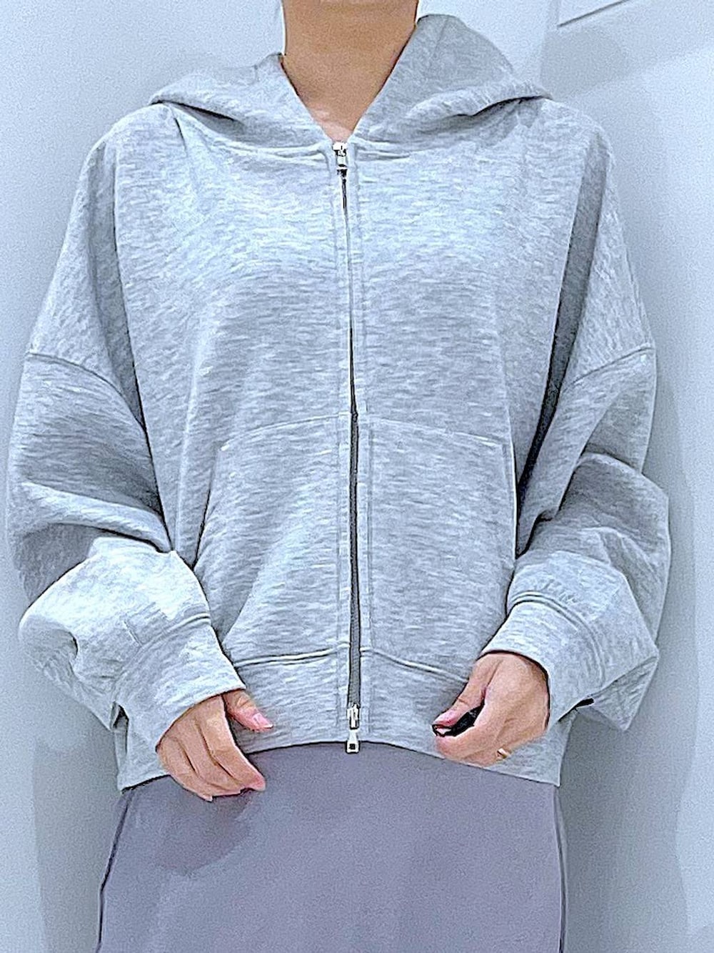 ブラック系のブーツ、グレー系のスカート、グレー系のパーカーを着用したレディースの春コーディネートの7枚目の写真