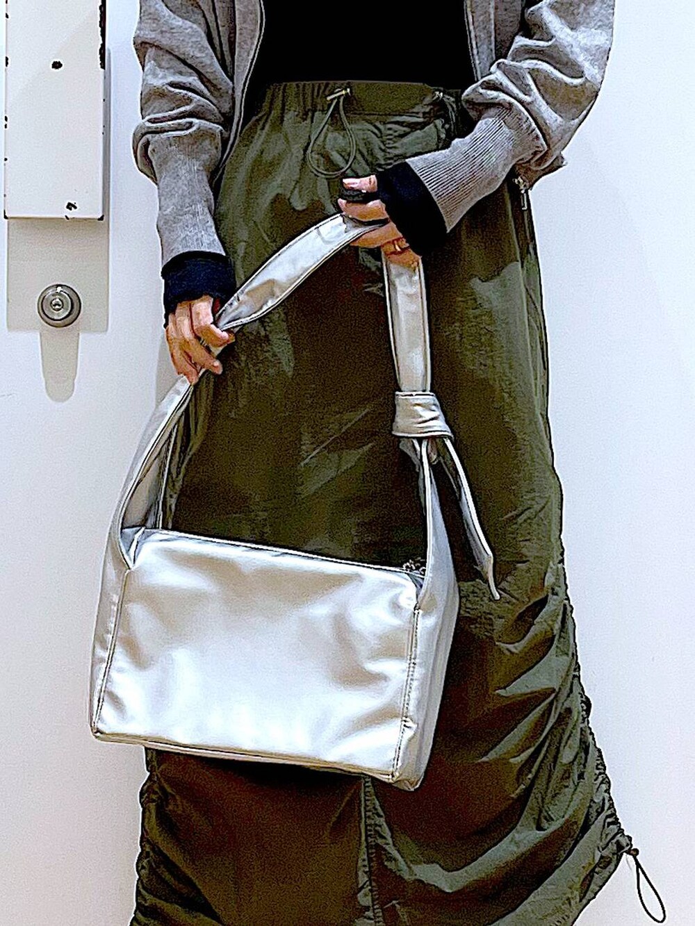 ブラック系のTシャツ/カットソー、グレー系のカーディガン/ボレロ、ブラック系のブーツを着用したレディースの冬コーディネートの9枚目の写真