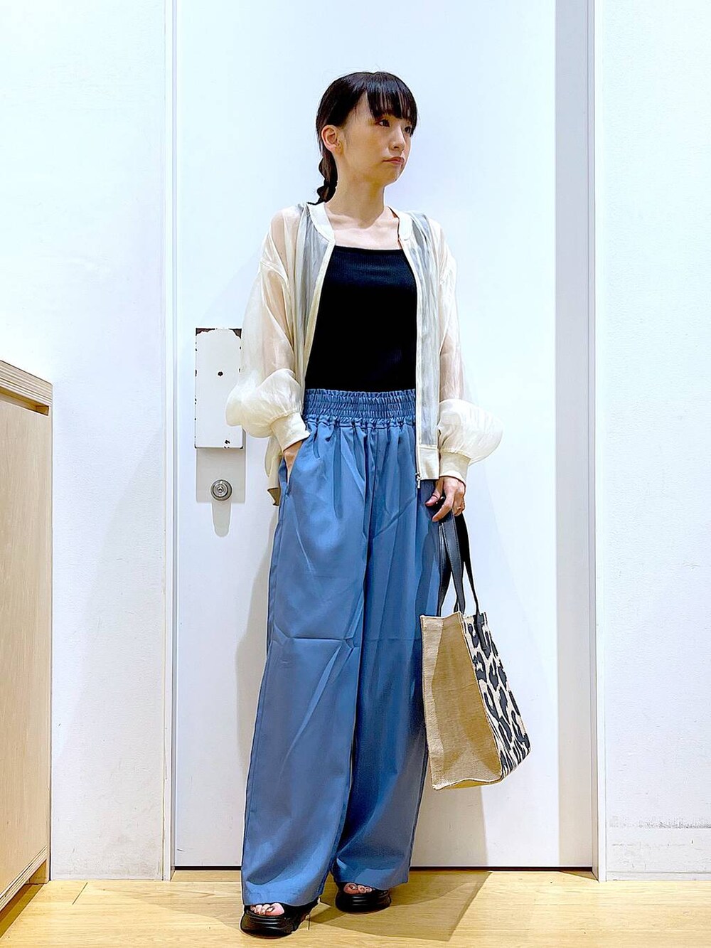 ブラック系のサンダル、ベージュ系のブルゾン、ブラック系のTシャツ/カットソーを着用したレディースの夏コーディネートの2枚目の写真