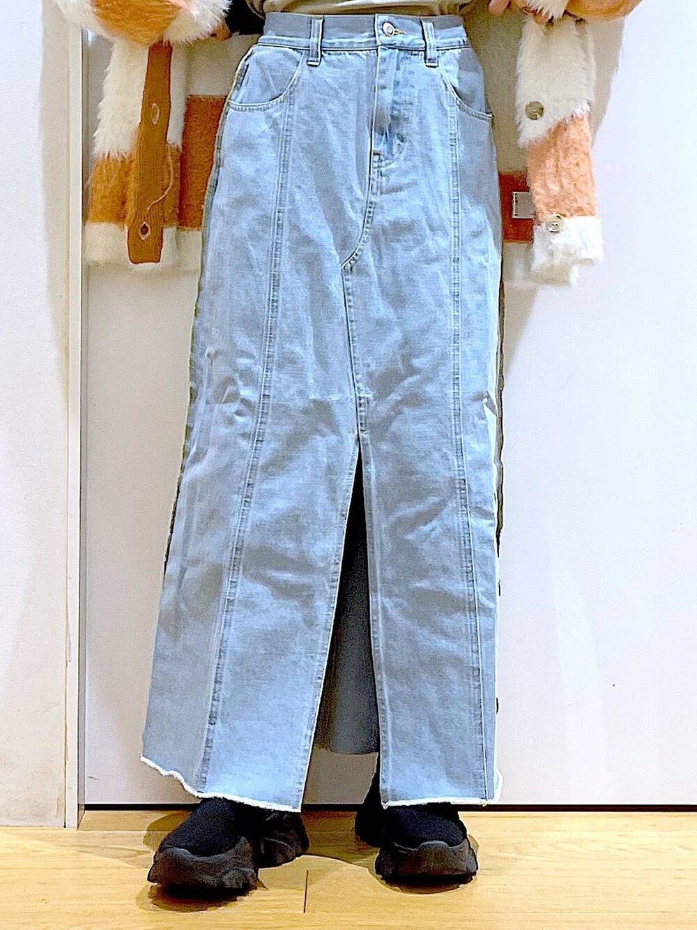 ベージュ系のショルダーバッグ、ブルー系のデニムスカート、ブラック系のブーツを着用したレディースの冬コーディネートの8枚目の写真