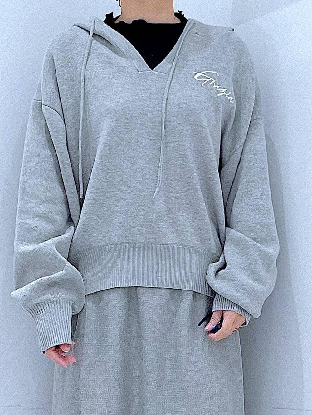 ブラック系のTシャツ/カットソー、グレー系のスカート、ホワイト系のショルダーバッグを着用したレディースの春コーディネートの7枚目の写真