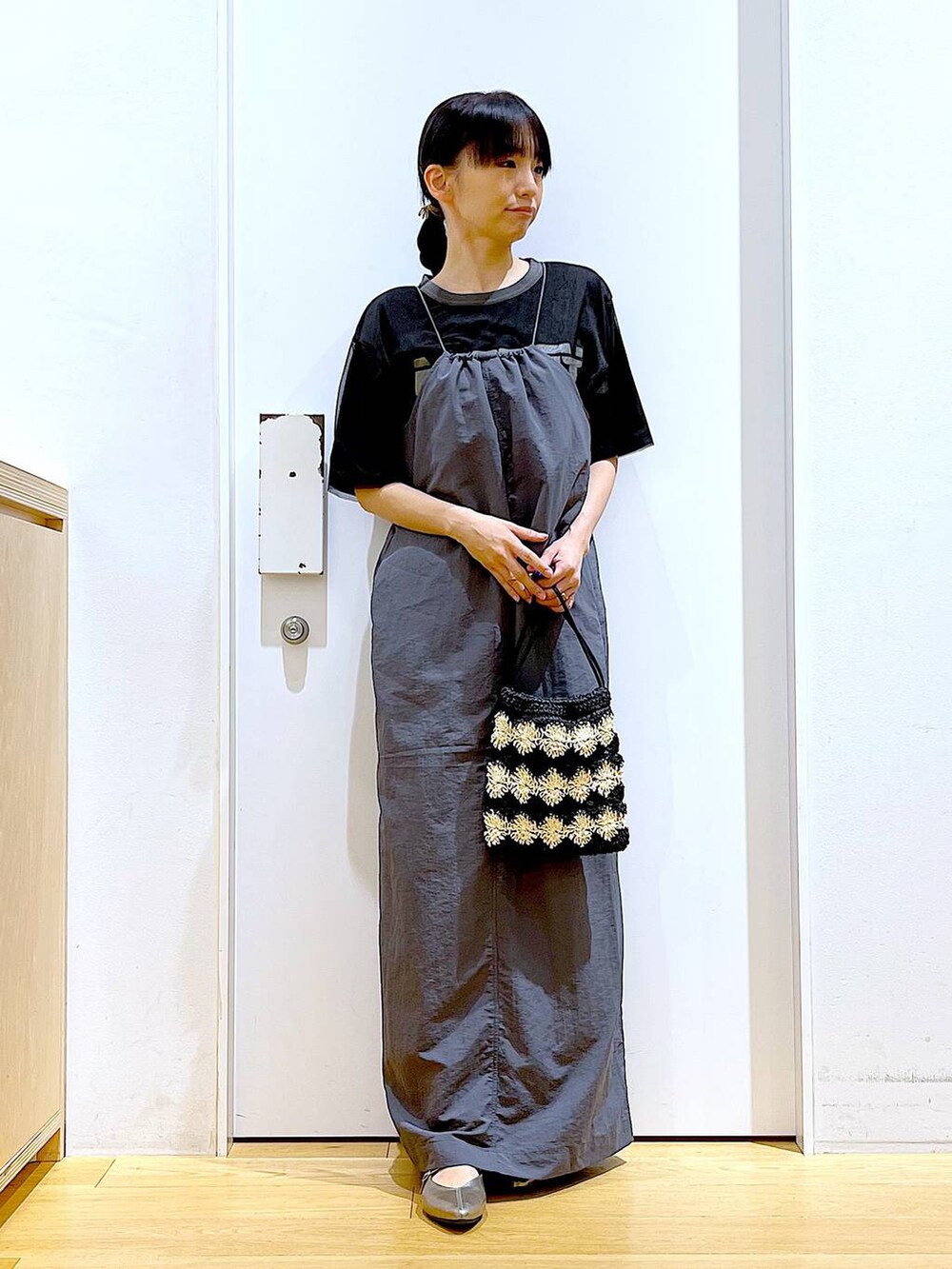 ブラック系のワンピース、その他のパンプス、ブラック系のショルダーバッグを着用したレディースの春コーディネートの2枚目の写真
