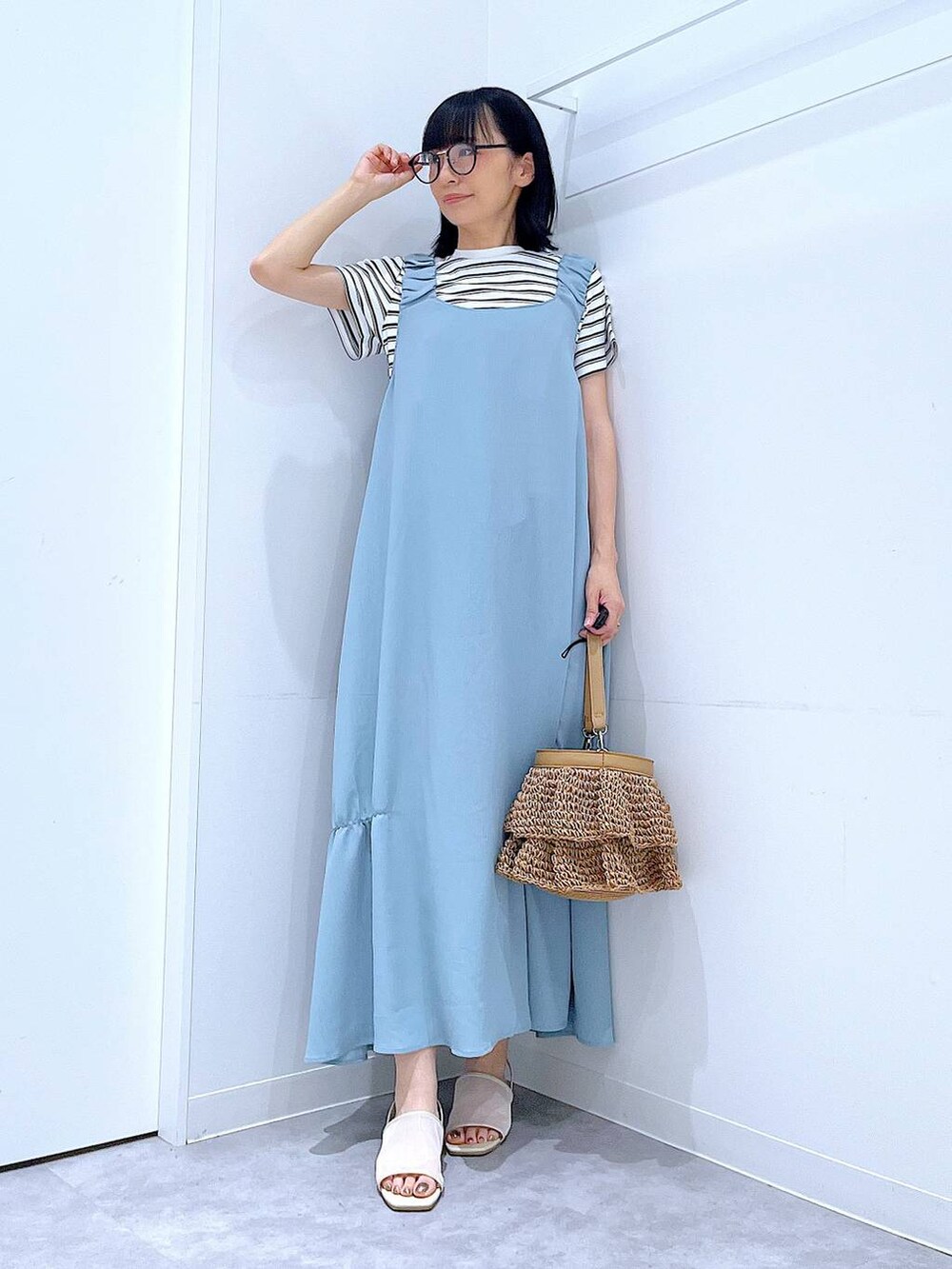 ベージュ系のショルダーバッグ、ホワイト系のサンダル、ベージュ系のTシャツ/カットソーを着用したレディースの夏コーディネートの2枚目の写真