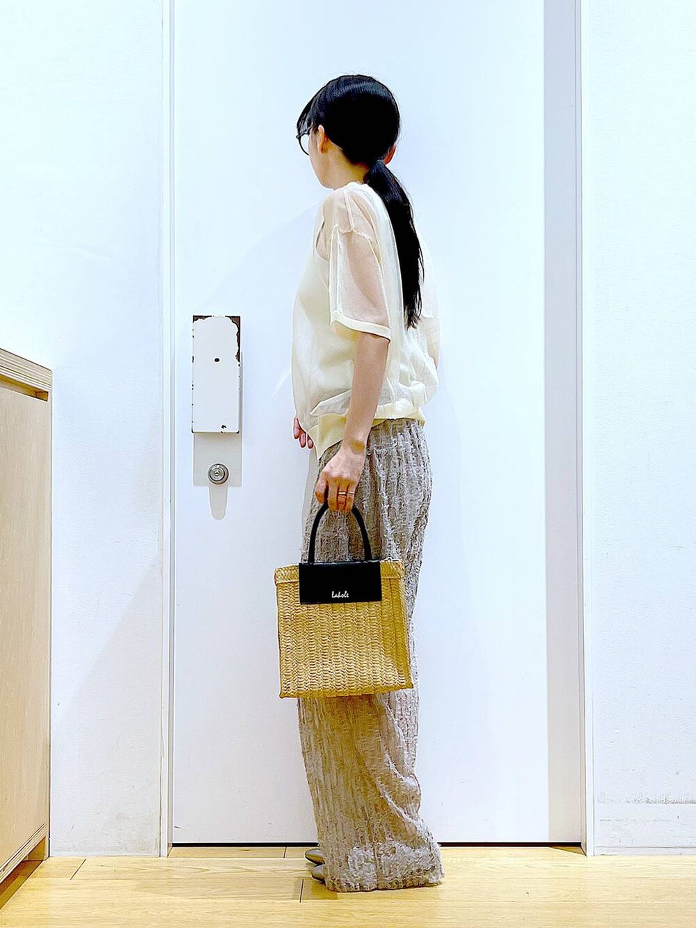 ホワイト系のニット/セーター、ベージュ系のその他パンツ、ホワイト系のニット/セーターを着用したレディースの夏コーディネートの3枚目の写真