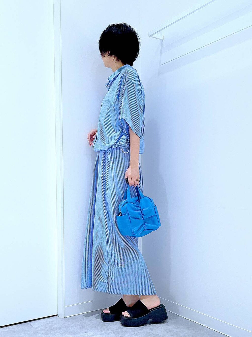 ブラック系のサンダル、ブルー系のワンピースを着用したレディースの夏コーディネートの3枚目の写真