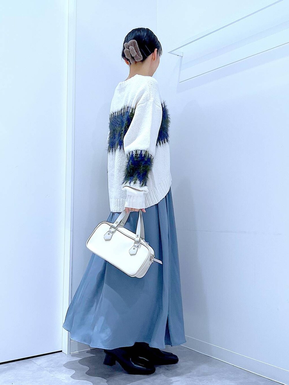 ブラック系のブーツ、ホワイト系のショルダーバッグ、ホワイト系のニット/セーターを着用したレディースの冬コーディネートの4枚目の写真