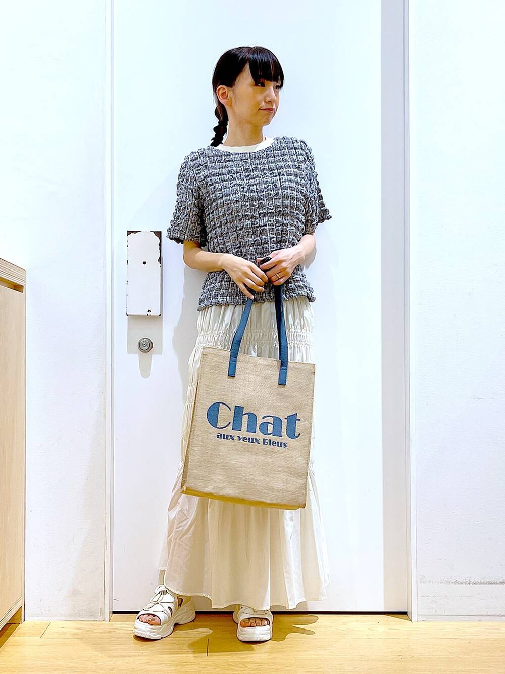 ホワイト系のサンダル、ブルー系のトートバッグ、その他のTシャツ/カットソーを着用したレディースの夏コーディネートの2枚目の写真