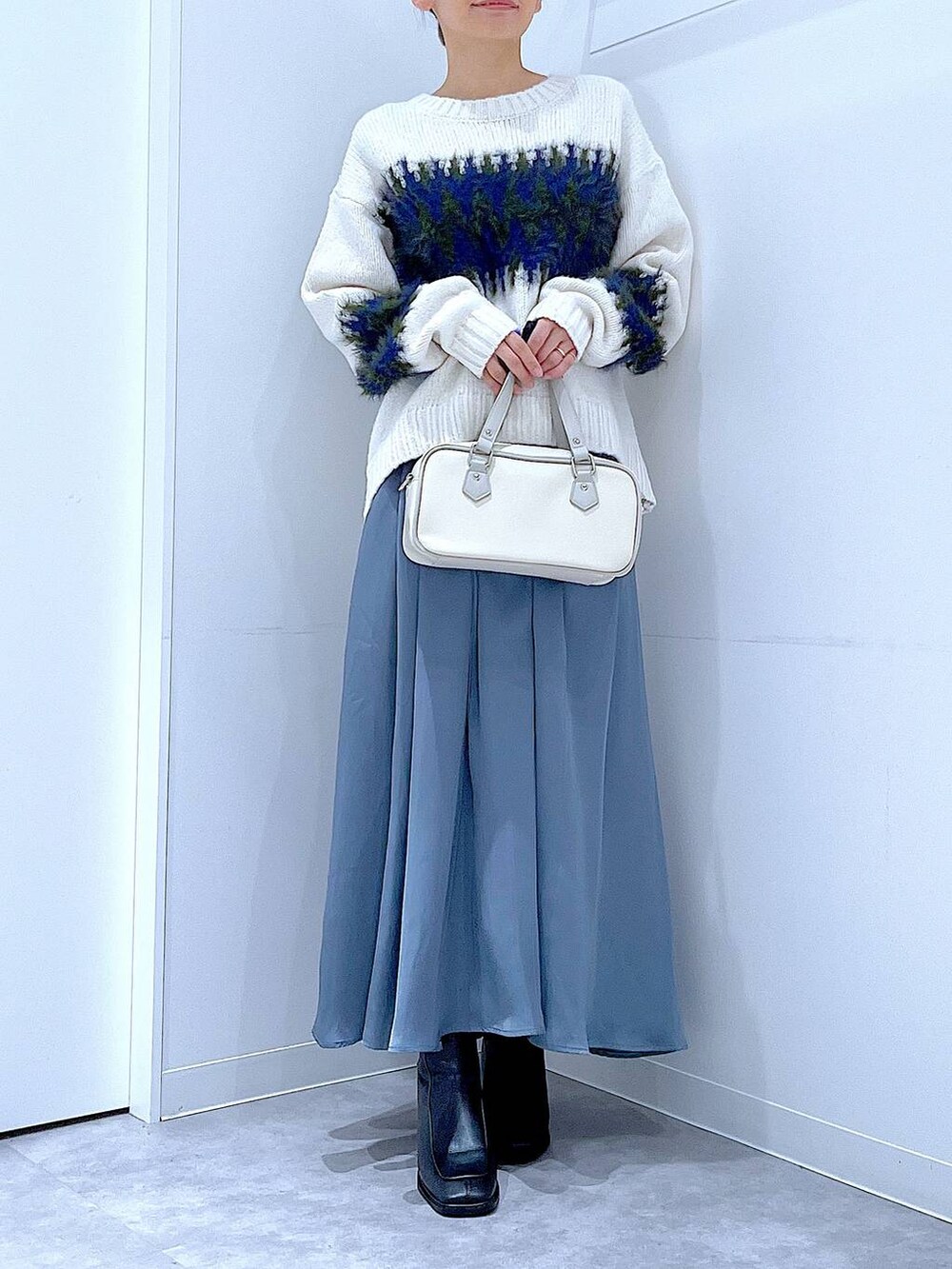 ブラック系のブーツ、ホワイト系のショルダーバッグ、ホワイト系のニット/セーターを着用したレディースの冬コーディネートの6枚目の写真