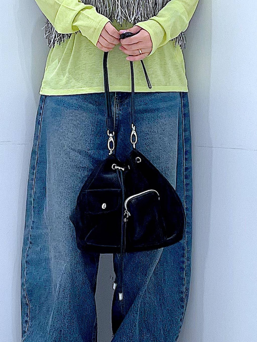 ブルー系のデニムパンツ、グリーン系のTシャツ/カットソー、ブラック系のショルダーバッグを着用したレディースの春コーディネートの9枚目の写真